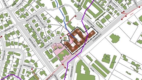 Drawn map depicting city streets and buildings from overhead with a section and new buildings designated with different colors from the rest of the map.