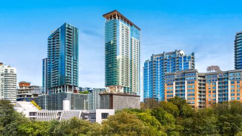 Rendering of a few tall buildings in downtown Austin with 700 River in the middle. Standard glass high-rise with a roof over its open roof deck on top.