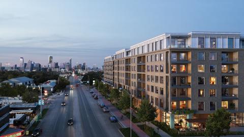 Rendering of a very large, seven-story rectangular mixed-use building overlooking a wide avenue at dusk.